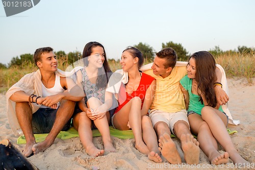 Image of smiling friends in sunglasses on summer beach