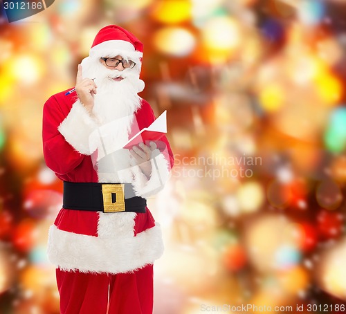 Image of man in costume of santa claus with notepad