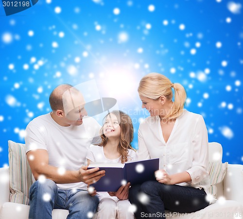 Image of happy family with book at home