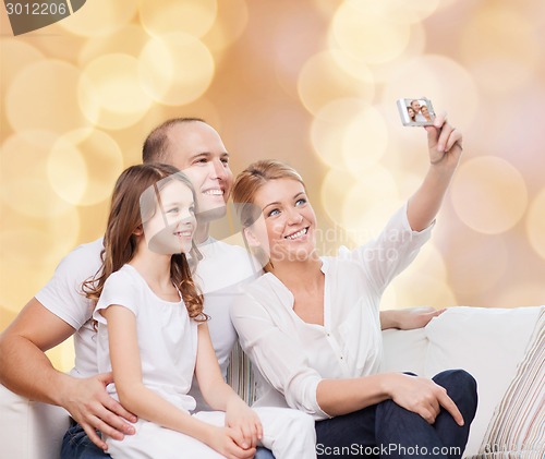 Image of happy family with camera at home