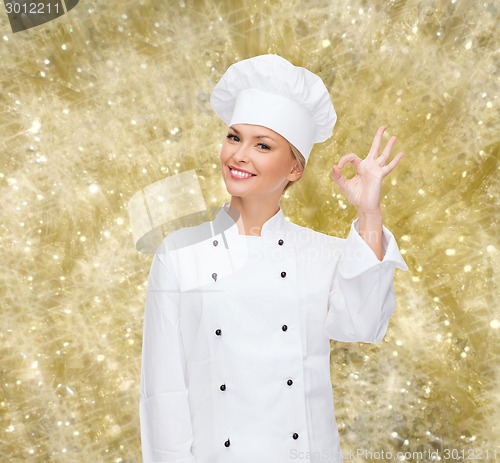 Image of smiling female chef showing ok sign