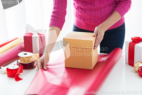 Image of close up of woman decorating christmas presents