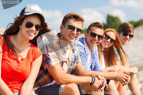 Image of close up of smiling friends sitting on city street