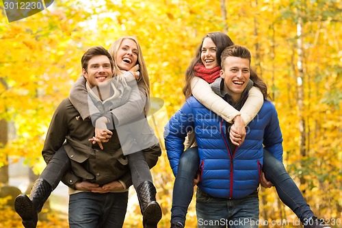 Image of smiling friends having fun in autumn park