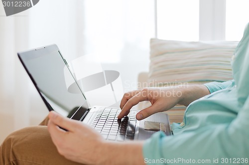 Image of close up of man working with laptop at home