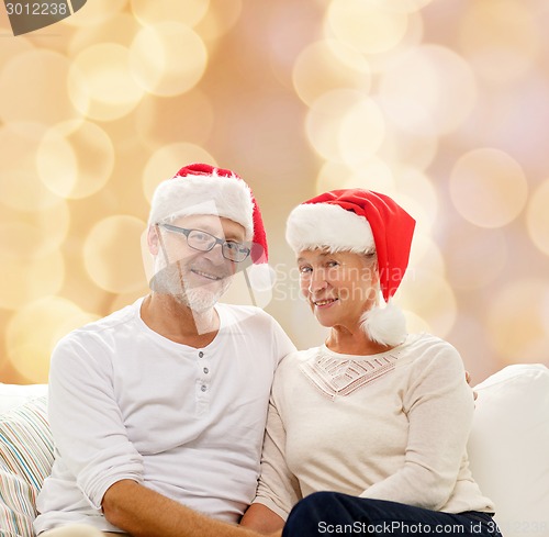 Image of happy senior couple in santa helper hats