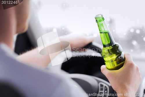 Image of close up of man drinking alcohol while driving car