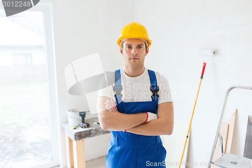 Image of builder in hardhat with working tools indoors