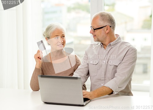 Image of happy senior couple with laptop and credit card