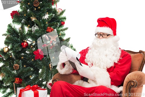 Image of man in costume of santa claus with notepad