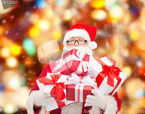 Image of man in costume of santa claus with gift boxes