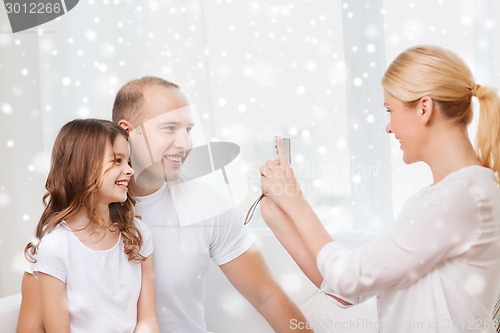 Image of happy family with camera taking picture at home