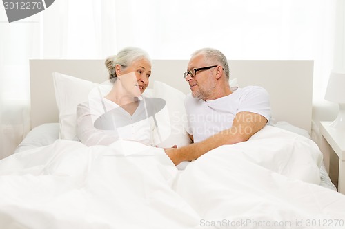 Image of happy senior coupler lying in bad at home