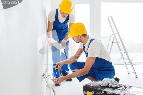 Image of builders with tablet pc and equipment indoors