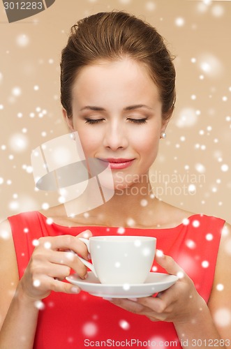 Image of smiling woman in red dress with cup of coffee