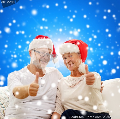 Image of happy senior couple in santa helper hats