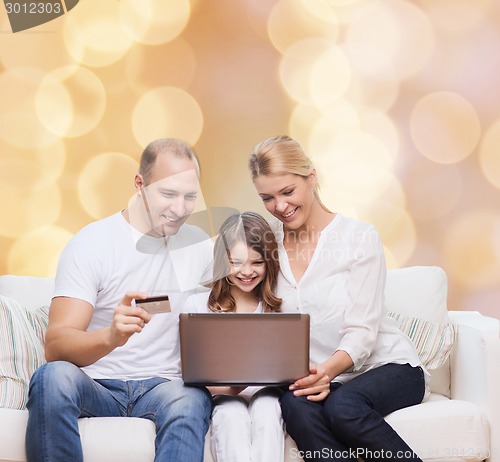 Image of happy family with laptop computer and credit card