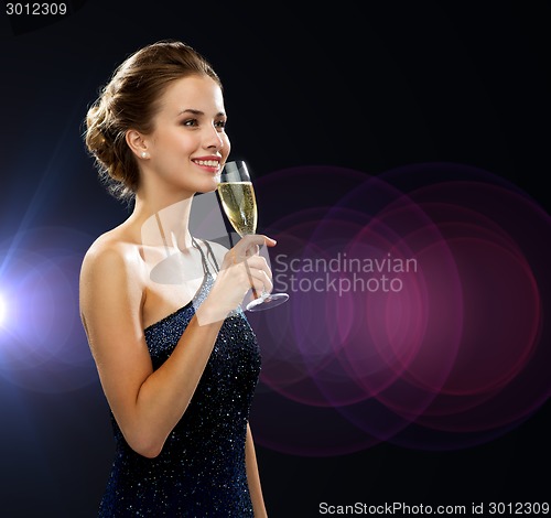 Image of smiling woman holding glass of sparkling wine