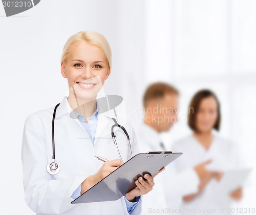 Image of smiling female doctor with clipboard