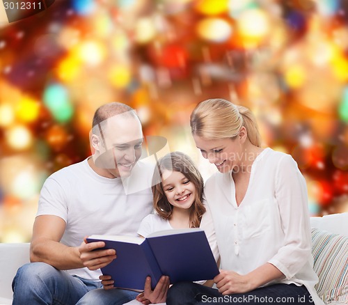 Image of happy family with book at home