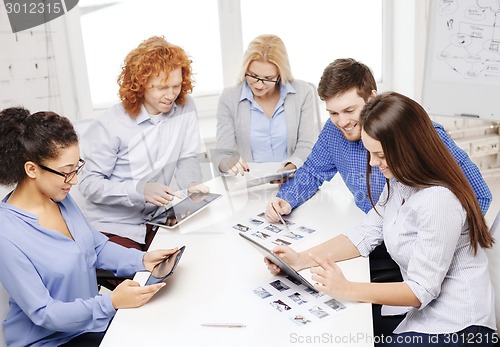 Image of smiling team with table pc and papers working