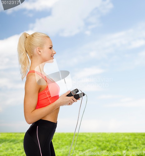 Image of smiling sporty woman with skipping rope