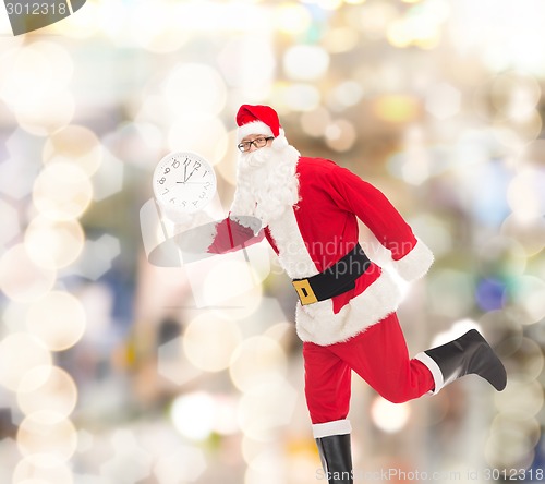 Image of man in costume of santa claus with clock