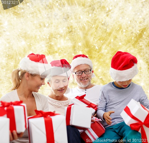 Image of happy family in santa helper hats with gift boxes