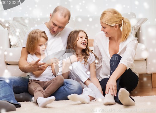 Image of smiling parents and two little girls at home