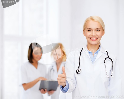 Image of smiling female doctor showing thumbs up