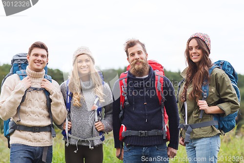 Image of group of smiling friends with backpacks hiking