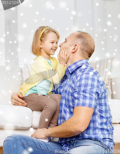 Image of smiling father and daughter hugging at home