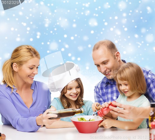 Image of happy family with two kids making salad at home