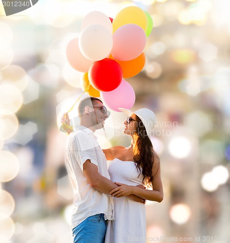 Image of smiling couple with air balloons outdoors