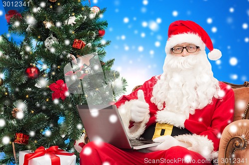 Image of man in costume of santa claus with laptop