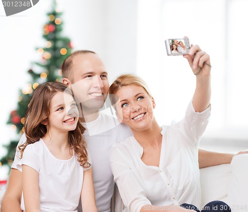 Image of happy family with camera at home