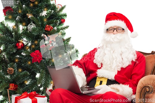 Image of man in costume of santa claus with laptop