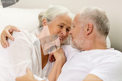 Image of happy senior coupler lying in bad at home