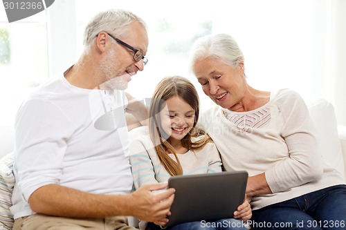 Image of smiling family with tablet pc at home