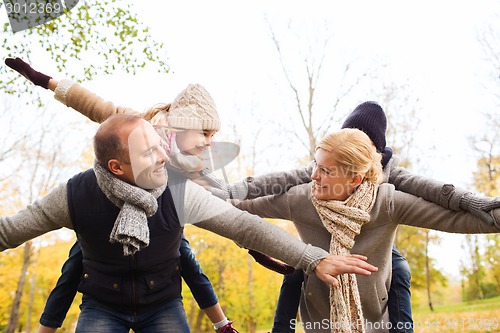 Image of happy family having fun in autumn park