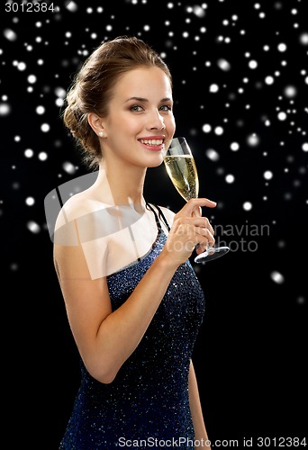 Image of smiling woman holding glass of sparkling wine