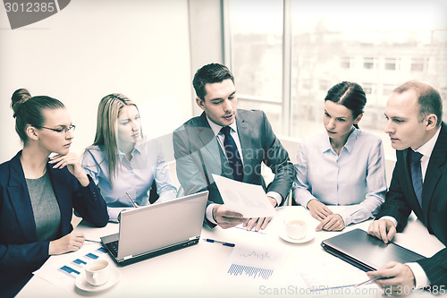 Image of business team with laptop having discussion