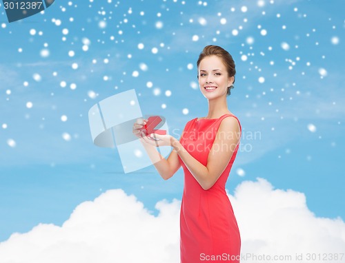 Image of smiling young woman in red dress with gift box