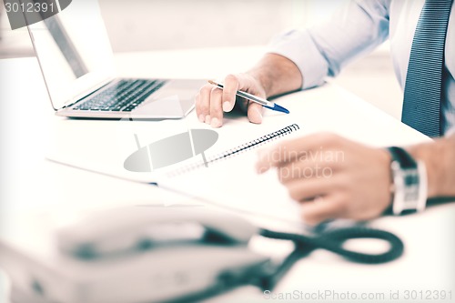 Image of businessman writing in notebook