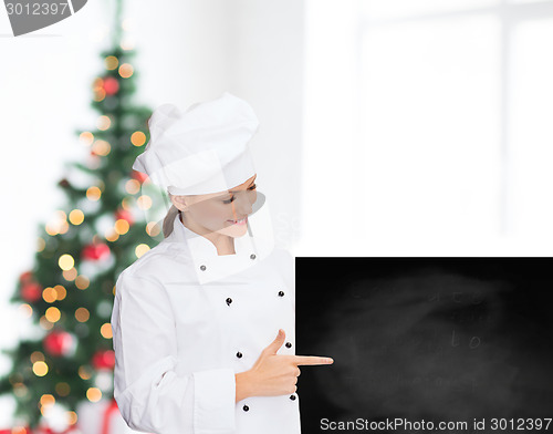 Image of smiling female chef with white blank board