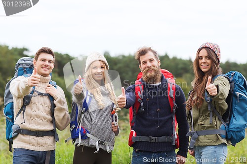 Image of group of smiling friends with backpacks hiking