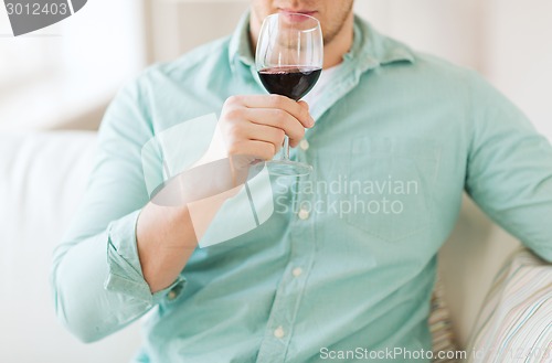 Image of close up of man drinking wine at home