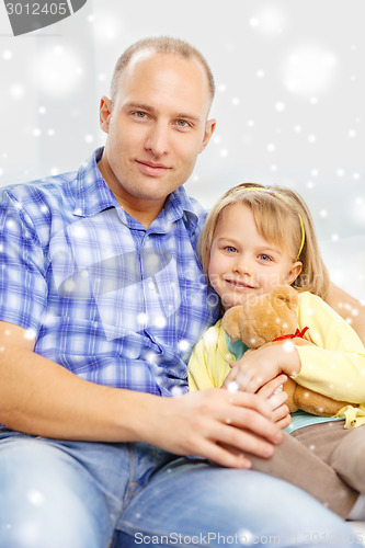Image of smiling father and daughter with teddy bear