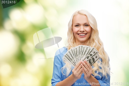 Image of smiling young woman with us dollar money