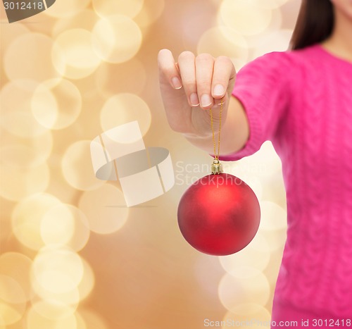 Image of close up of woman in sweater with christmas ball